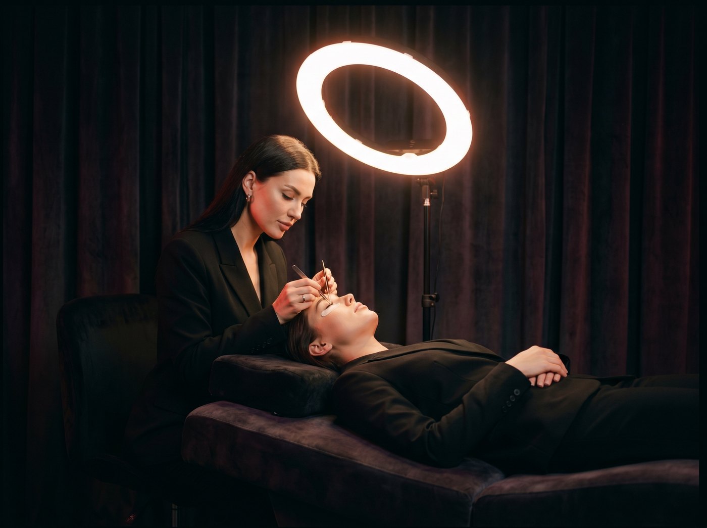 A lash artist working under a ring light